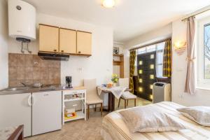 莫托文的住宿－Apartments with a parking space Motovun, Central Istria - Sredisnja Istra - 14160，厨房以及带1张床和1张桌子的卧室