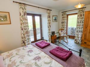 - une chambre avec un lit doté d'oreillers violets dans l'établissement Field Barn, à Alston