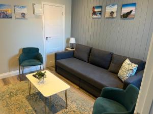 a living room with a couch and a table and chairs at Pier Plain By The Sea in Gorleston-on-Sea
