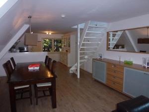 a kitchen and dining room with a table and a staircase at Schiphol Apartments in Aalsmeer