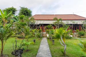 a house with a pathway in front of a yard at Karang Agartha Lembongan in Nusa Lembongan
