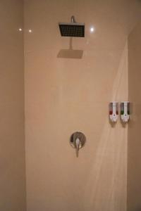 a bathroom with a shower with two glasses on the wall at Karang Agartha Lembongan in Nusa Lembongan