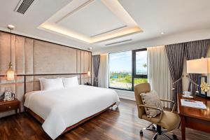 Ravatel Luxury Hotel Bac Giang في Bắc Giang: غرفة نوم بسرير ومكتب وكرسي