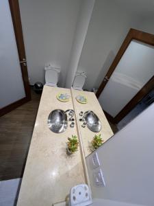 een keuken met een tafel met 2 wastafels en een koelkast bij Plano Vertical in San Miguel de Tucumán