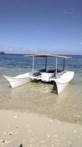 盧納將軍城的住宿－Anajawan Island Beachfront Resort，两艘船坐在海滩边