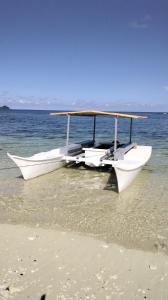 dois barcos sentados na costa de uma praia em Anajawan Island Beachfront Resort em General Luna