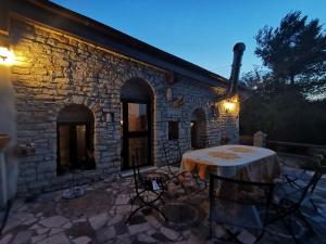 a table and chairs in front of a stone building at Trulli Vittoria in Putignano