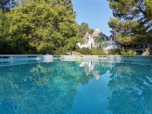 a pool of water with a house in the background at Trulli Vittoria in Putignano