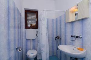 a blue tiled bathroom with a toilet and a sink at Apartments by the sea Cove Pjestata, Peljesac - 14440 in Ston