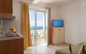 a kitchen with a sliding glass door to the beach at Apartments with a parking space Tucepi, Makarska - 14457 in Tučepi