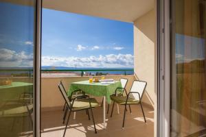 a table and chairs on a balcony with a view of the ocean at Apartments with a parking space Tucepi, Makarska - 14457 in Tučepi