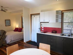 kuchnia i sypialnia z łóżkiem i umywalką w obiekcie Redrock Retreat w mieście Kingaroy