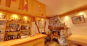 a room with a fireplace and a shelf of bottles at Hôtel Le Lievre Blanc in Vars