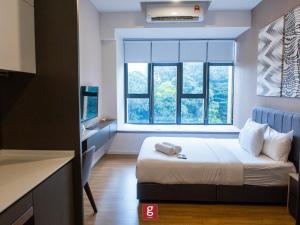 a bedroom with a bed and a large window at Ceylonz KLCC by Gsuites in Kuala Lumpur