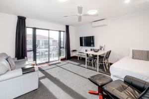 a bedroom with a bed and a table with chairs at Palms Motel in Nelson