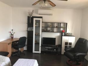 ein Wohnzimmer mit einem Schreibtisch, Stühlen und einem TV in der Unterkunft Apartments with a parking space Brodarica, Sibenik - 16470 in Šibenik
