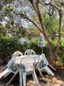 une table avec quatre chaises et un parasol dans l'établissement Apartment Mira - affordable & comfortable, à Supetar