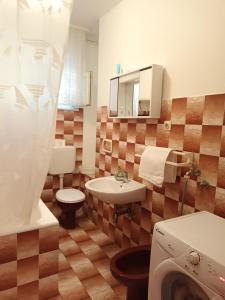 La salle de bains est pourvue d'un lavabo, de toilettes et d'un miroir. dans l'établissement Apartment Mira - affordable & comfortable, à Supetar