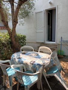une table et des chaises avec une table et un arbre dans l'établissement Apartment Mira - affordable & comfortable, à Supetar