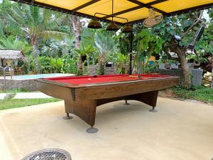 una mesa de billar con una cubierta roja en el patio en Barong Resort en Ban Phe