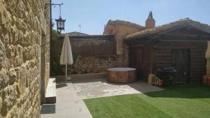 un patio al aire libre con mesa y sombrilla en CASA RURAL PALACIO LOS LABREQUINES, en Villacomparada de Rueda