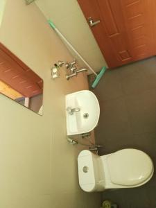 W łazience znajduje się toaleta, umywalka i lustro. w obiekcie The Lake Paradise Boutique Resort w mieście Alappuzha