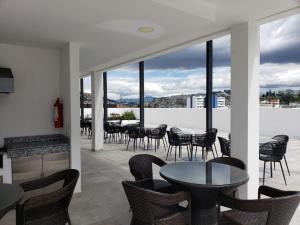 a patio with tables and chairs and windows at Hermoso departamento, céntrico y tranquilo in Quito