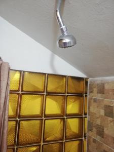 a shower with yellow glass tiles in a bathroom at Guest Room Asparuh in Troyan