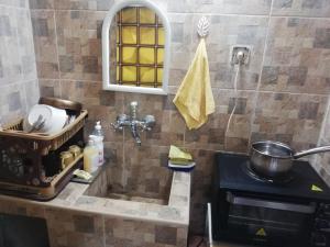 a bathroom with a sink and a pot on a stove at Guest Room Asparuh in Troyan