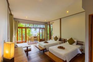 a bedroom with two beds and a balcony at Amaresa Resort & Sky Bar - experience nature in Haad Rin
