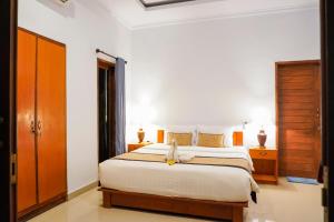 a bedroom with a large bed and wooden cabinets at Pemuntalan Guesthouse in Nusa Lembongan