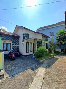 a house with a motorcycle parked in front of it at Villa petit Tour in Batu
