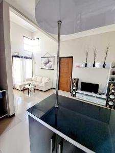 uma sala de estar com uma mesa de vidro no meio em Villa petit Tour em Batu