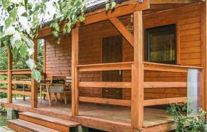 a log cabin with a porch and a table and chairs at 2 Bedroom Cozy Home In Leba-nowecin in Łeba