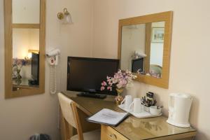 a desk with a television and a mirror at The Inn at Emmington in Chinnor