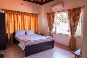 a bedroom with a bed and a large window at Sulo Villa in Malpe