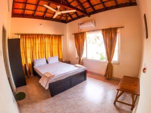a bedroom with a large bed and a window at Sulo Villa in Malpe