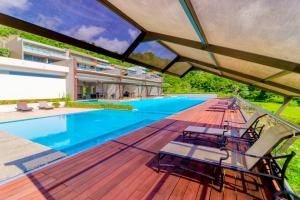 an outdoor deck with chairs and a swimming pool at Altos de Montserrat 2 1 in Herradura
