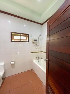 a bathroom with a tub and a toilet and a sink at Mingmongkol Resort in Koh Samui