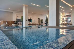 a large swimming pool in a hotel lobby at Queen Apartments Belgrade Waterfront in Belgrade