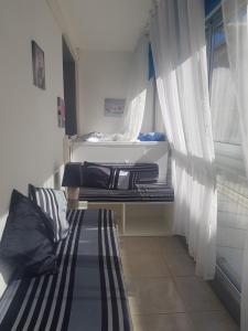 カネ・アン・ルシヨンにあるCanet centre ville et plage - Equipé avec climatisationのソファ、窓(カーテン付)が備わる客室です。