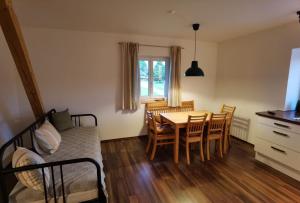 Zimmer mit einem Tisch und Stühlen sowie einem Schlafzimmer in der Unterkunft Niedergerner Alpaka Ranch in Haiming