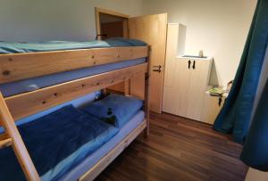 two bunk beds in a room with a door at Niedergerner Alpaka Ranch in Haiming