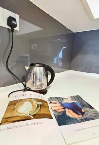 a coffee pot and a magazine on a table at C0814 Almas suites NETFLIX 100mbps By By STAY in Nusajaya