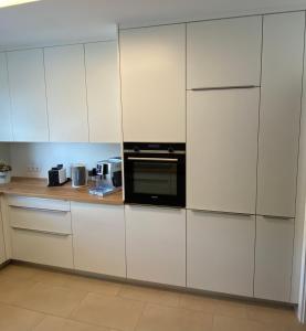 a kitchen with white cabinets and a microwave at Chebello in Koblenz