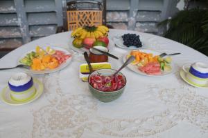 una mesa blanca con platos de fruta. en WEST ORANGE LODGE, en Moshi