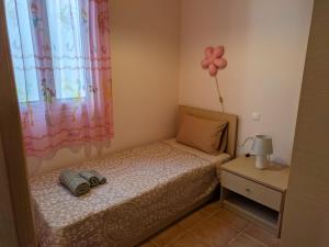 ein kleines Schlafzimmer mit einem Bett mit einer Blume an der Wand in der Unterkunft Sweet home of Kefalonia in Ayia Evfimia
