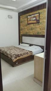 a bedroom with a bed and a brick wall at Hotel Vanya Palace By WB Inn in Agra