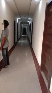 a person walking down a hallway in a building at Hotel Vanya Palace By WB Inn in Agra