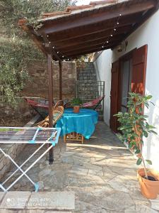 a patio with a table and chairs under an umbrella at Fousa Home in Poros